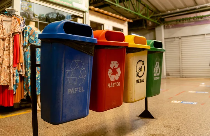 Coletores de recicláveis para papel, plástico, metal e vidro em um mercado coberto